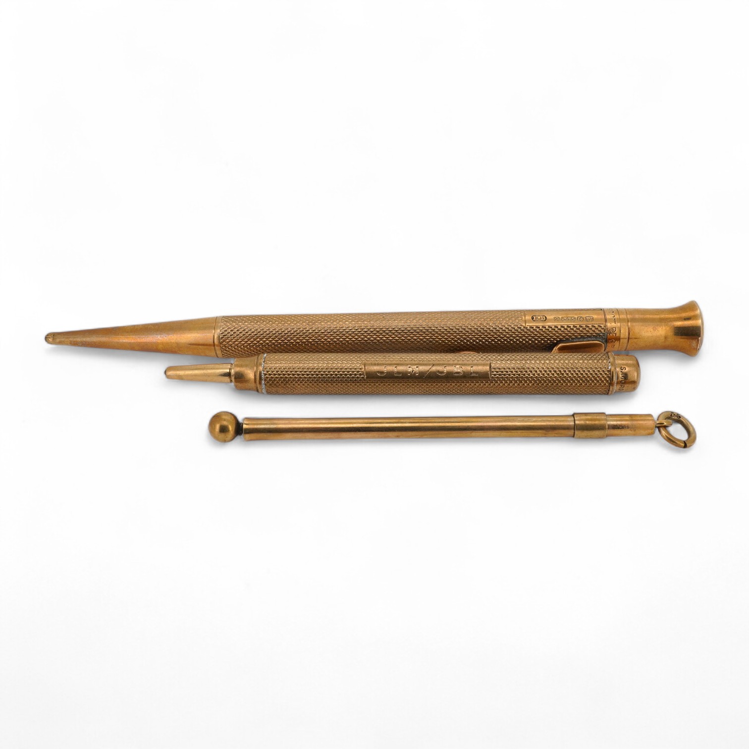 Two engine turned 9ct gold cased pencils including smallest by Sampson Mordan & Co, hallmarked for London, 1937, 7cm, the smaller with engraved inscription, together with a gold plated swizzle stick, larger pencil by E.